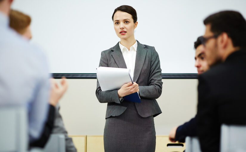 女性コーチが英語の講義を行っている