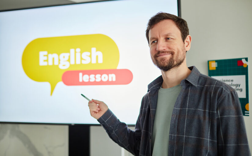 男性の英語の先生がデジタルホワイトボードを使って英語を教えている